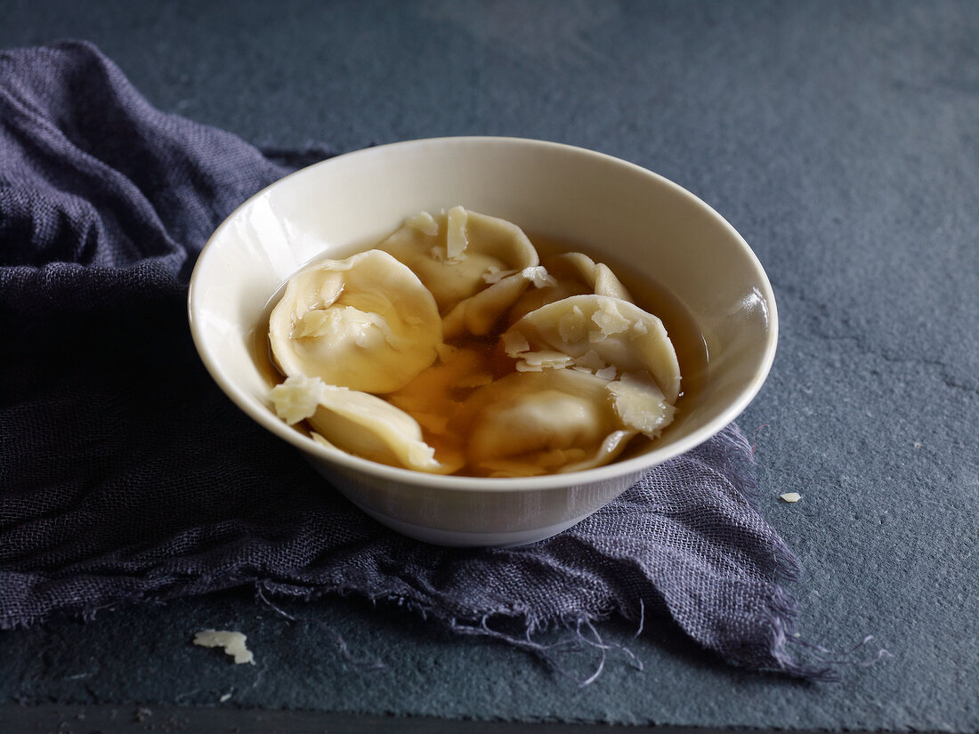 Tortellini with broth in bowl