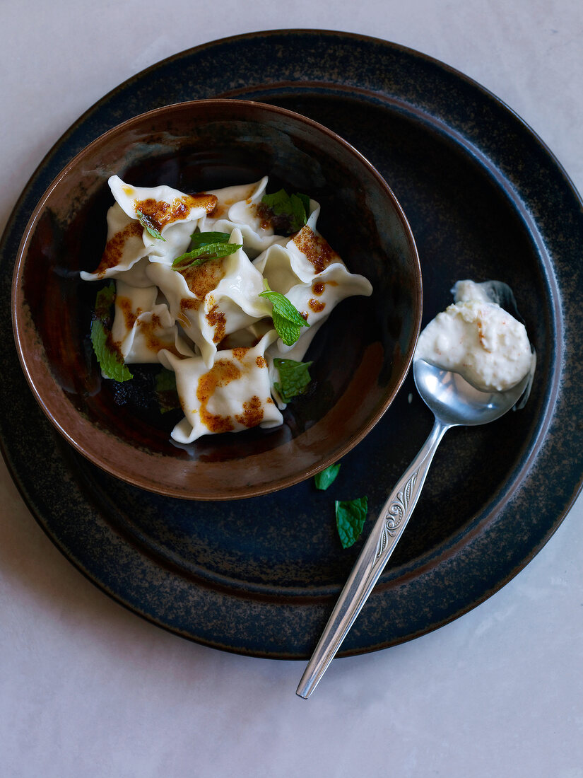 Manti with yogurt sauce in bowl