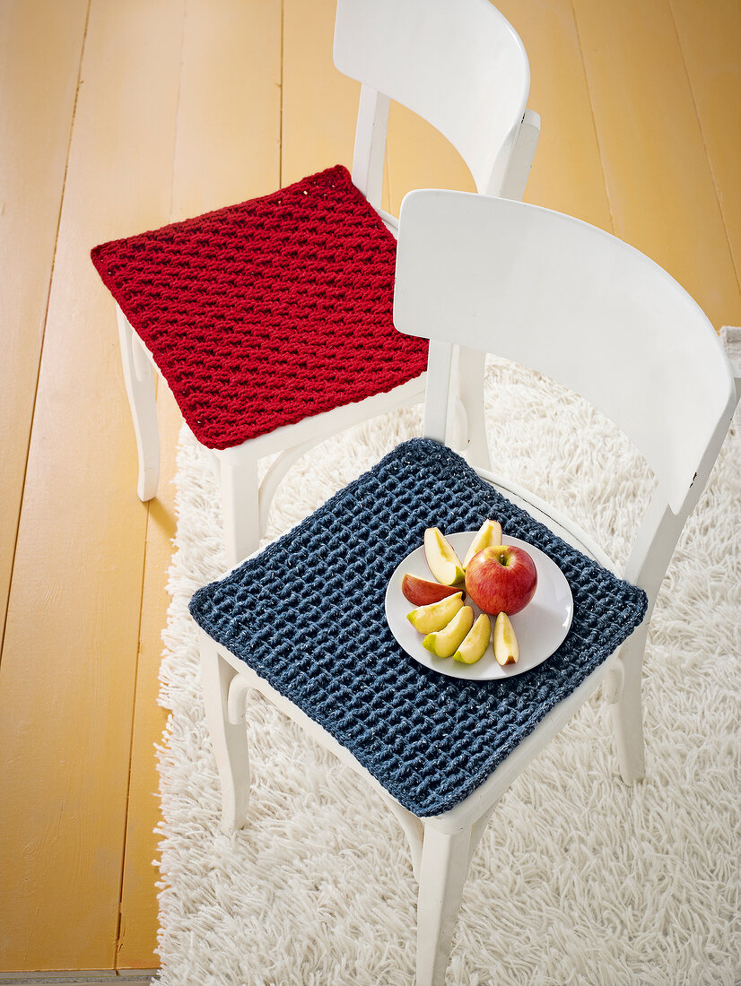Two chair with red and blue cushion and sliced apple plate