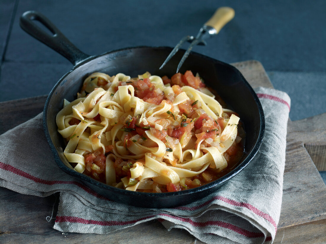 Ribbon pasta with tomato sauce and herbs in pan