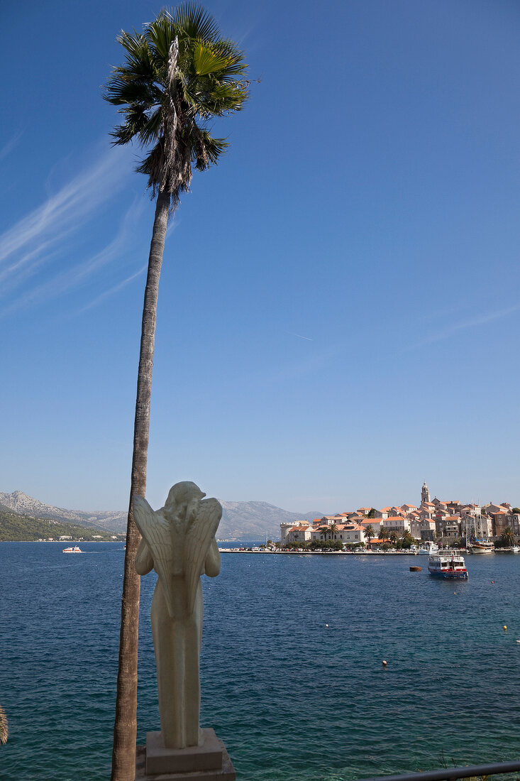 Rear view of statue with palm tree on Korcula port, Dubrovnik-Neretva, Croatia