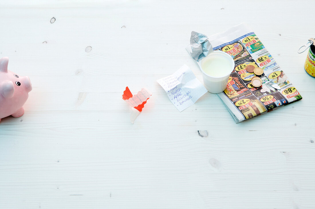 Papers, paper cup and piggy bank on white background
