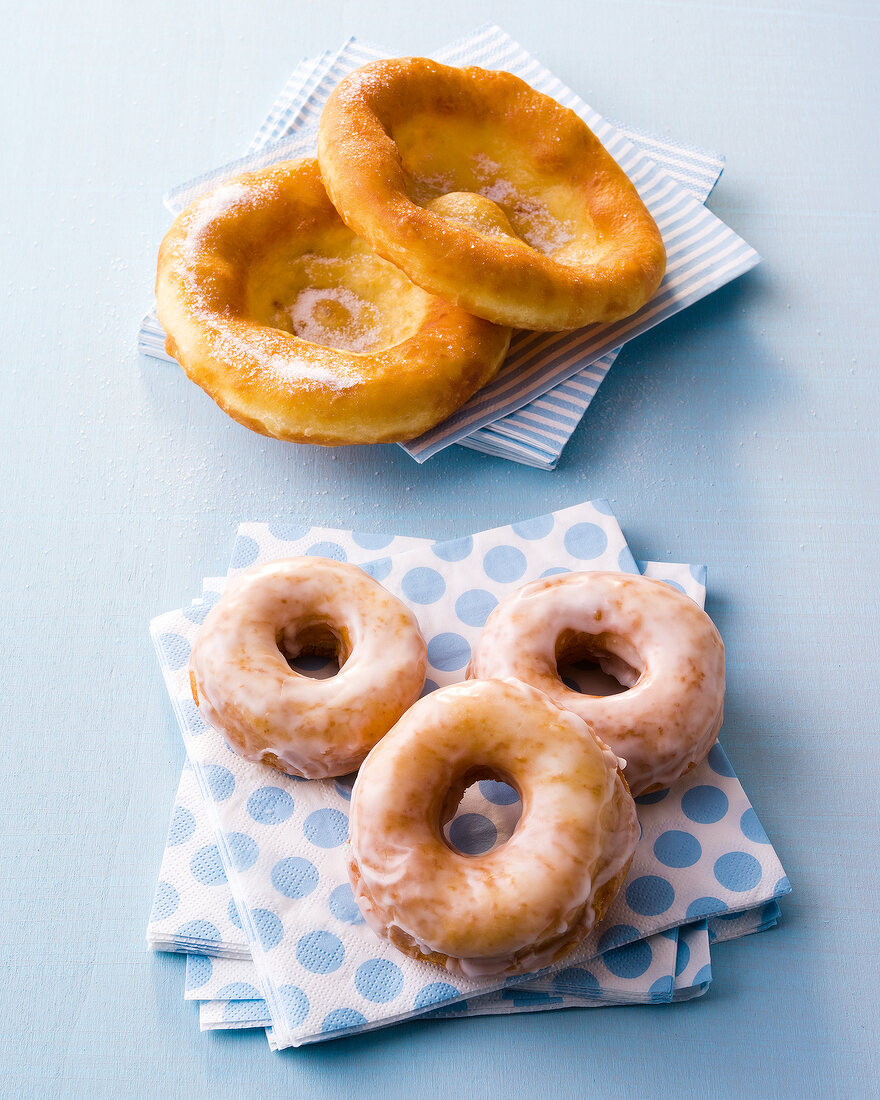 Yeast dough fritters and donuts on stacked paper napkins