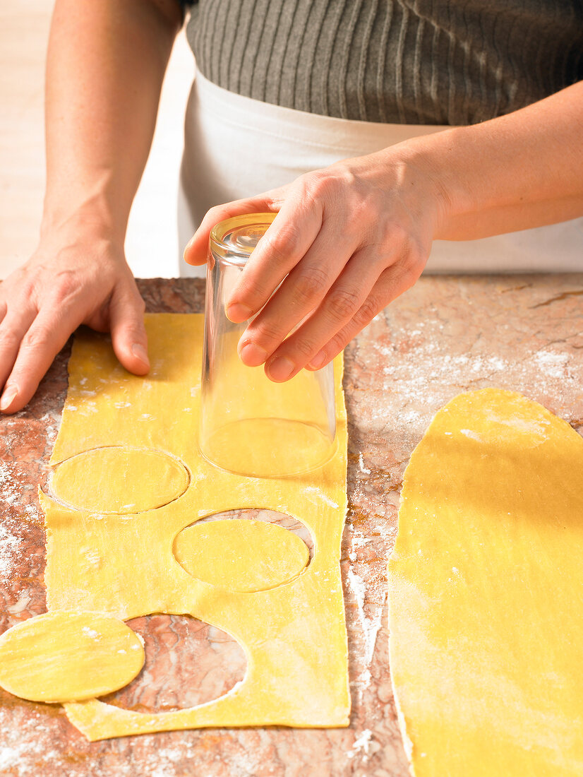 Close-up of hand cutting ravioli, step 1