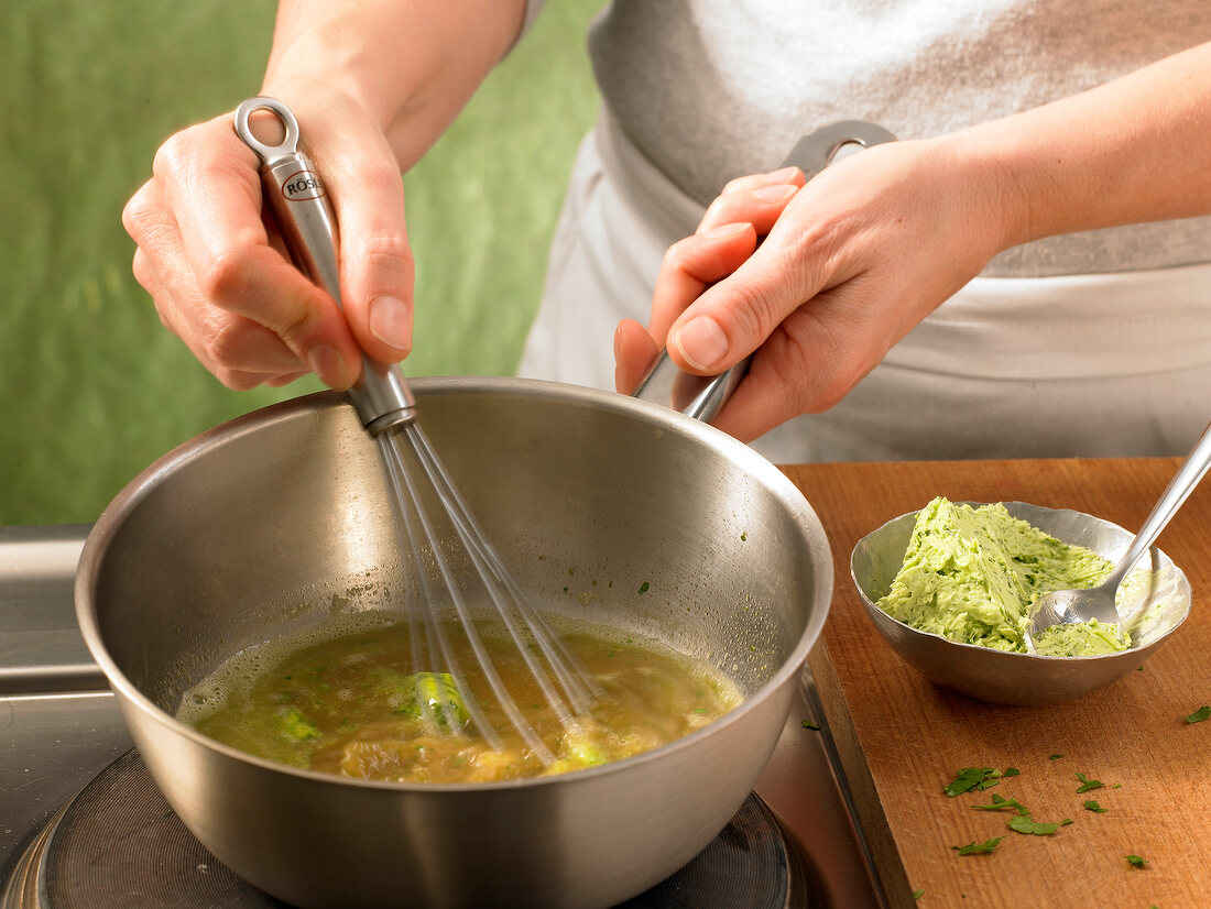 Close-up of hand cooking parsley sauce in pan