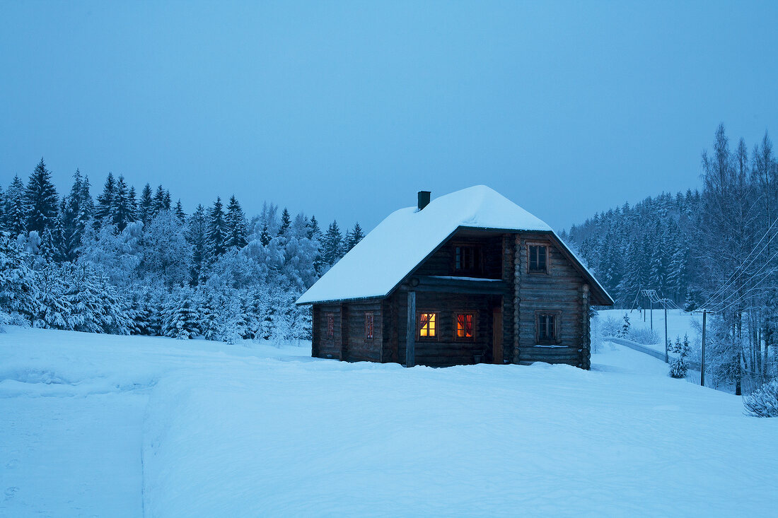 View of wooden holiday house in snowy mountains at night