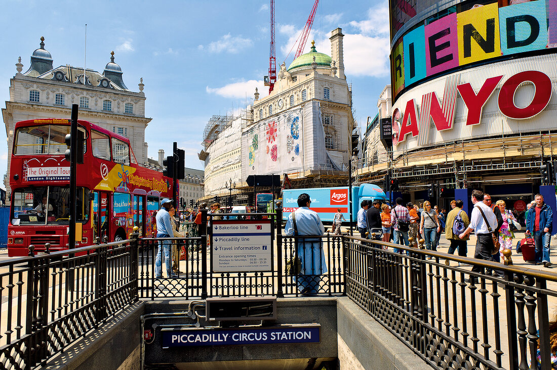 Tourist outside Piccadilly Circus Station in the City of Westminster, London, UK