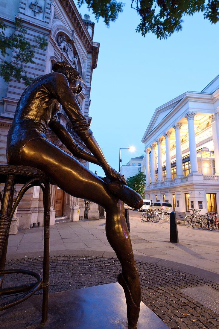 Two women photographing in front of sculpture, Covent Garden, London, UK