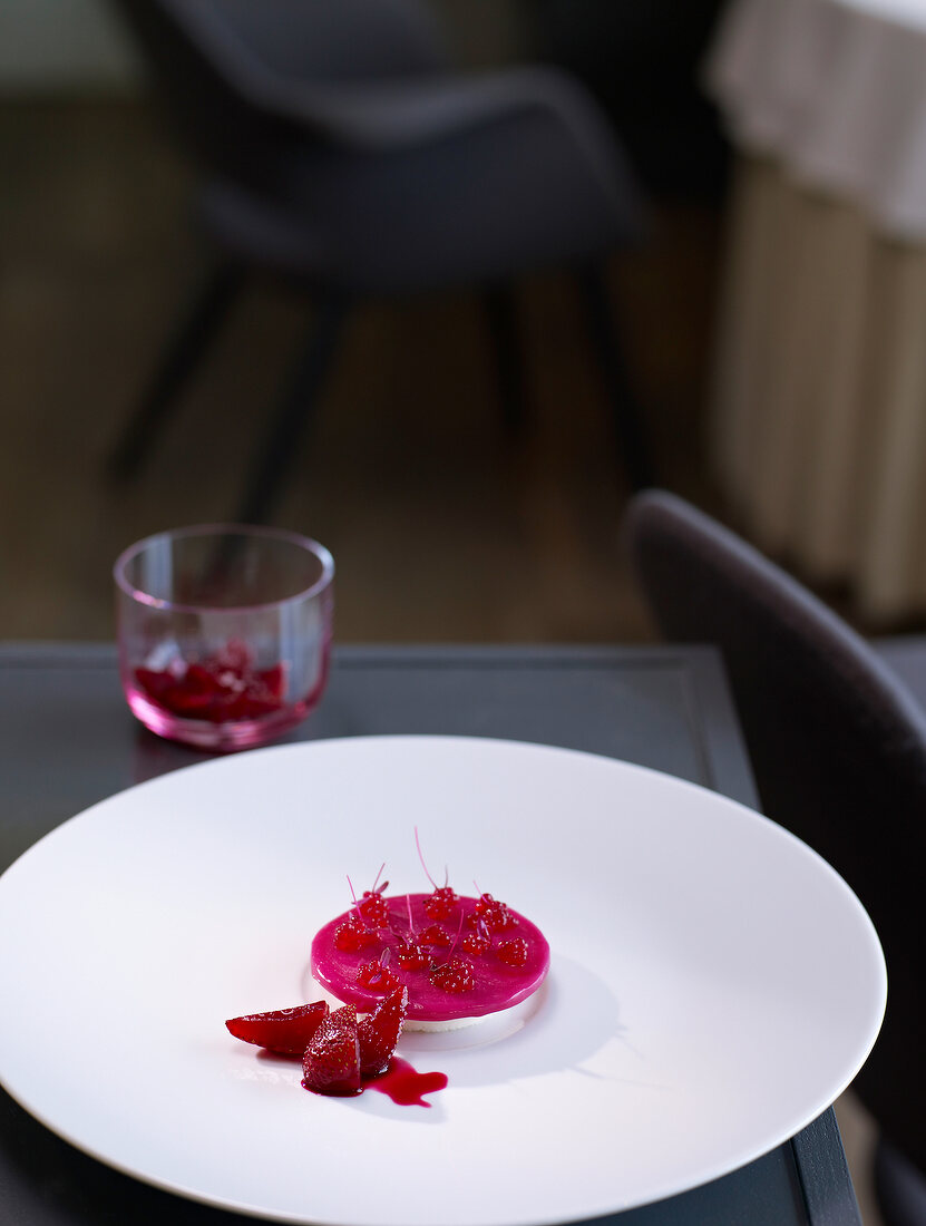 Yogurt with dried roses and strawberries on plate
