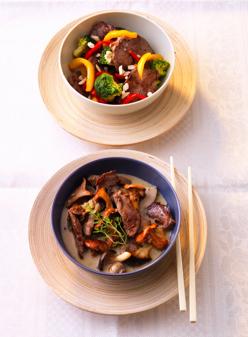 Beef stir-fry with vegetables and sliced duck with mushrooms in soup bowl