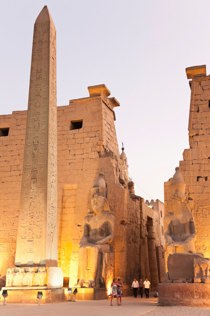People walking in front of illuminated Luxor Temple, Luxor, Egypt