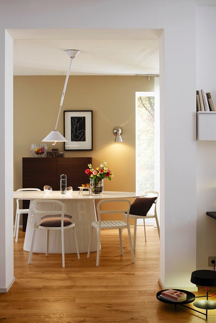 Blick in Esszimmer mit ovalem Tisch, Stühlen & moderner Hängeleuchte