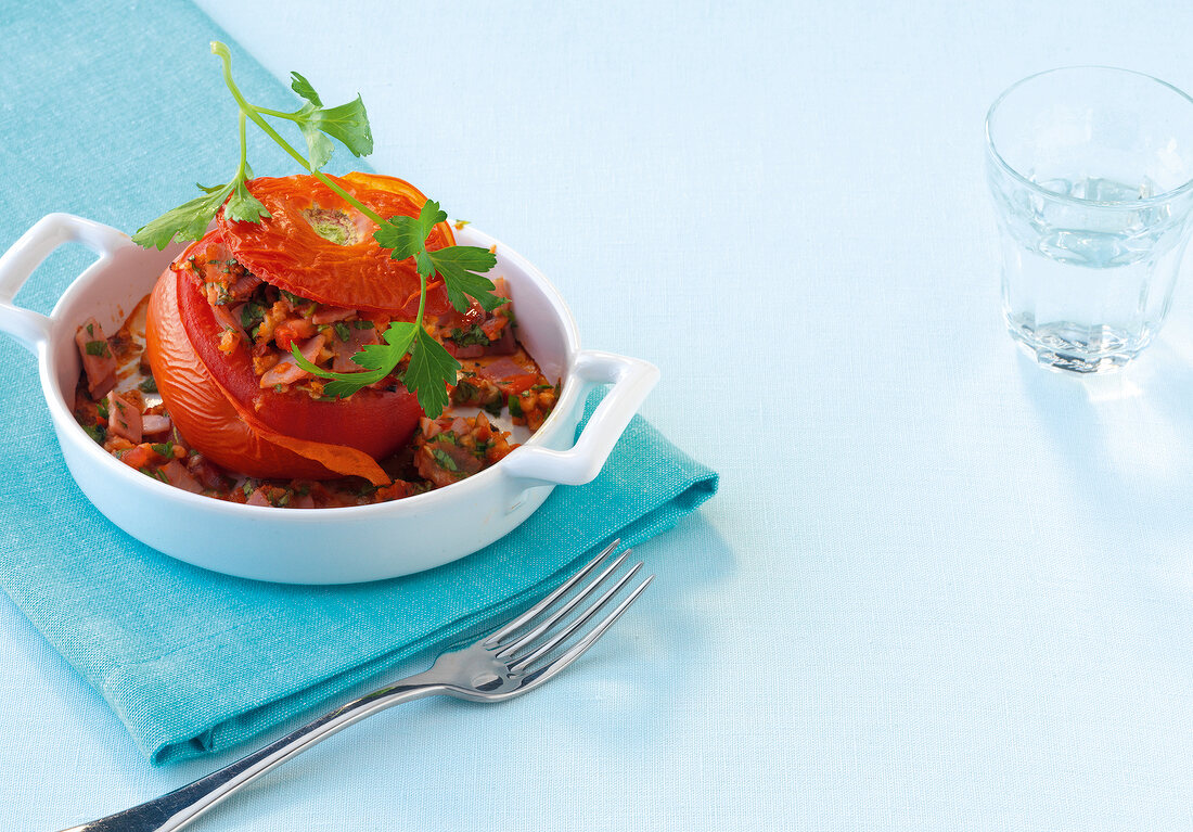 Baked tomato with filling in serving dish