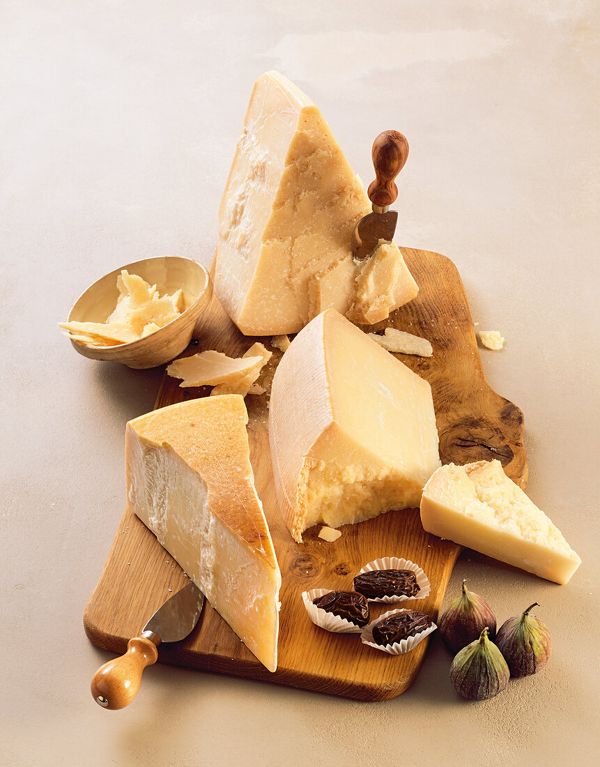 Various types of cheese and spices on wooden board