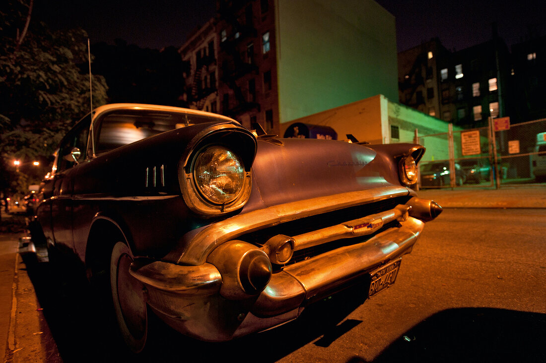 Vintage car on road at night in New York, USA