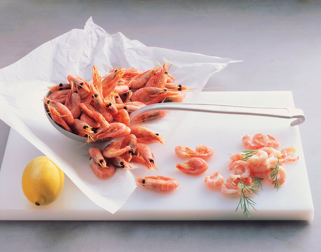 Shrimp with ladle and lemon on white background