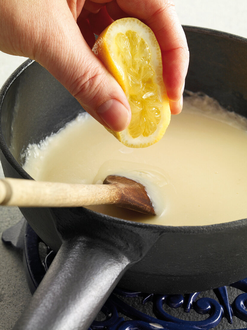 Raclette u. Fondue, Zitronensaft ins Käsefondue rühren