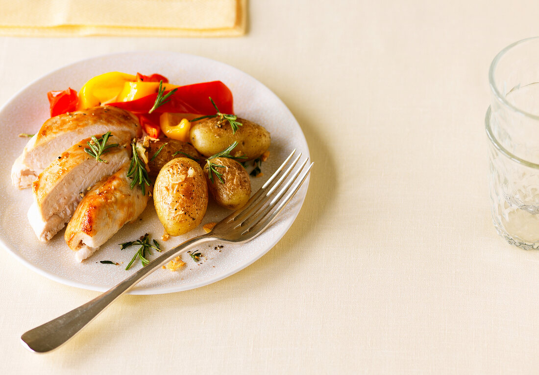 Baked chicken breast with herb and potatoes on plate