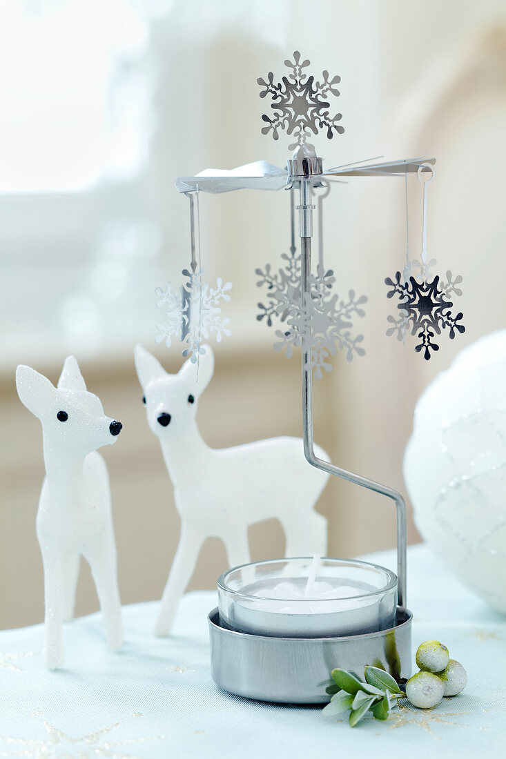 Candle stand with snowflakes and deer figure on side