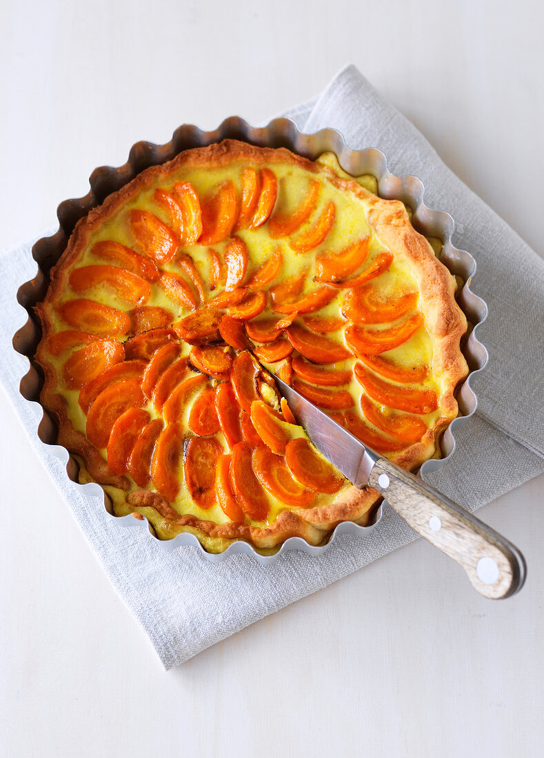 Carrot quiche with knife in baking tin