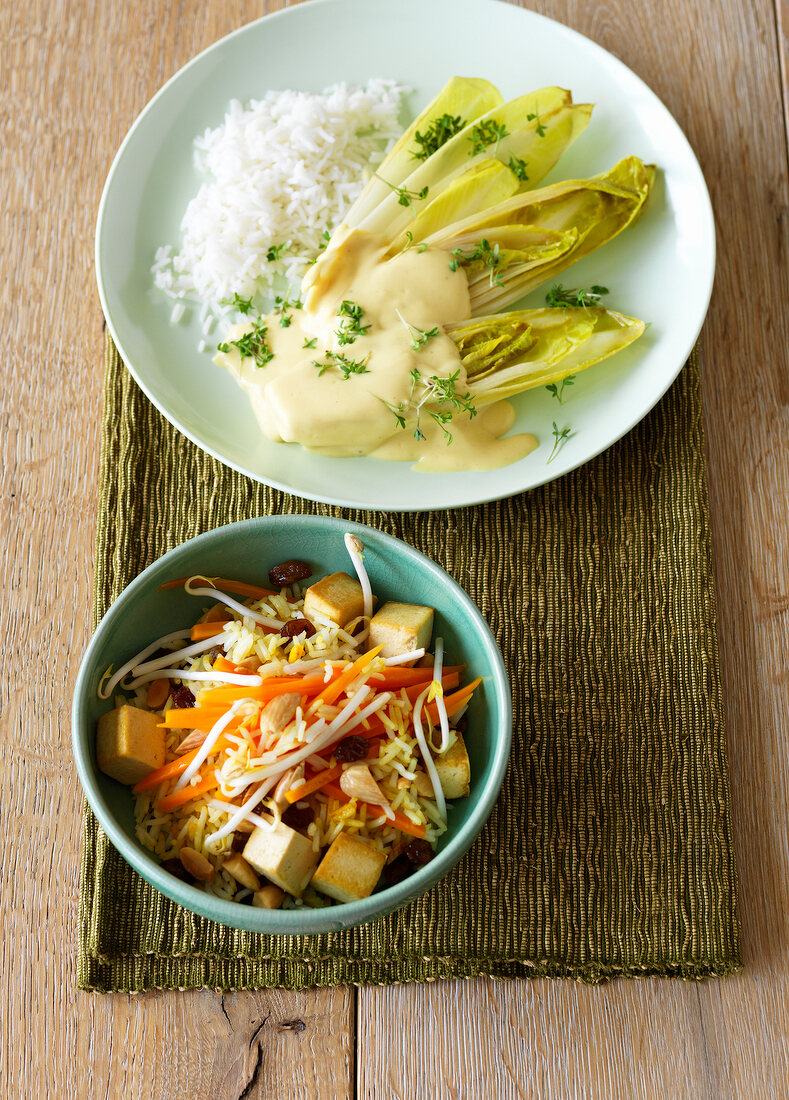 Bowl of chicory in mustard sauce and tofu and rice skillet on plate 
