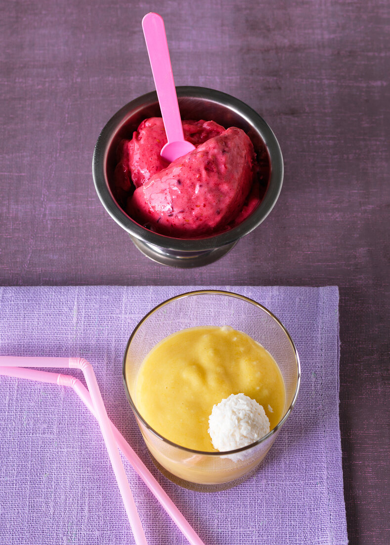 Bowl of raspberry ice cream and glass of mango smoothie