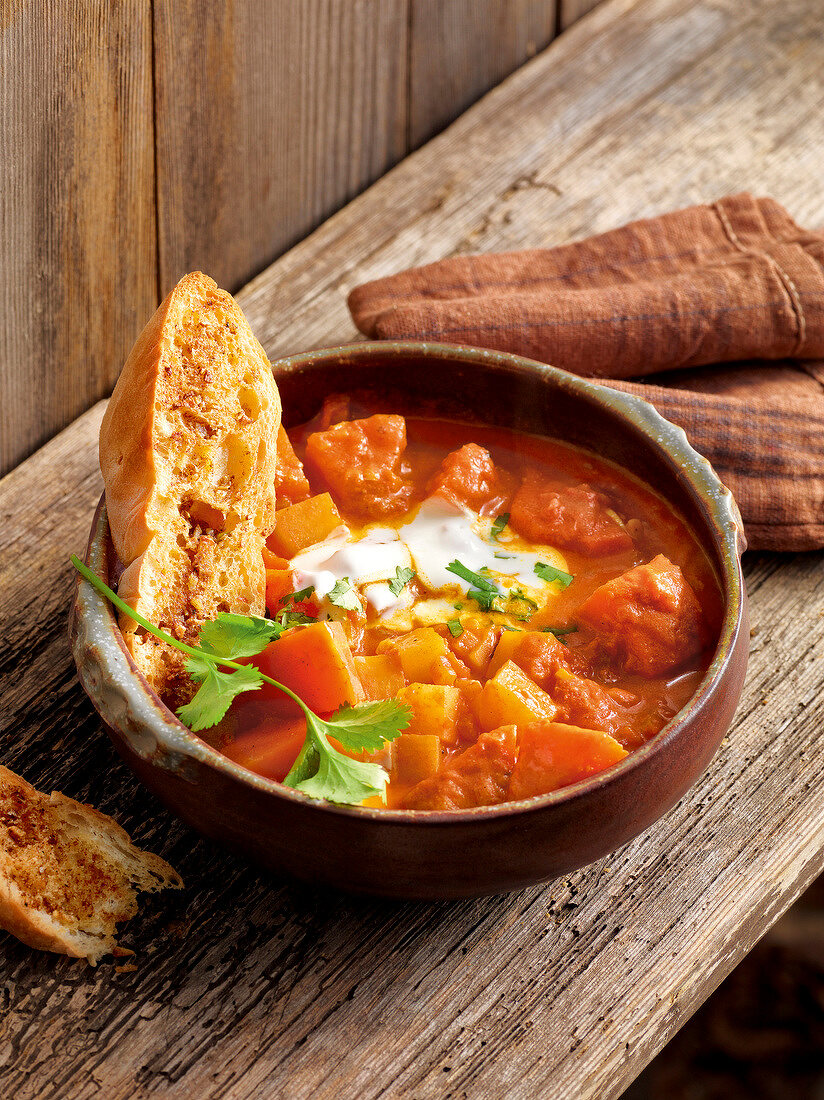 Pumpkin turnip curry with spiced pita bread in serving dish for winter