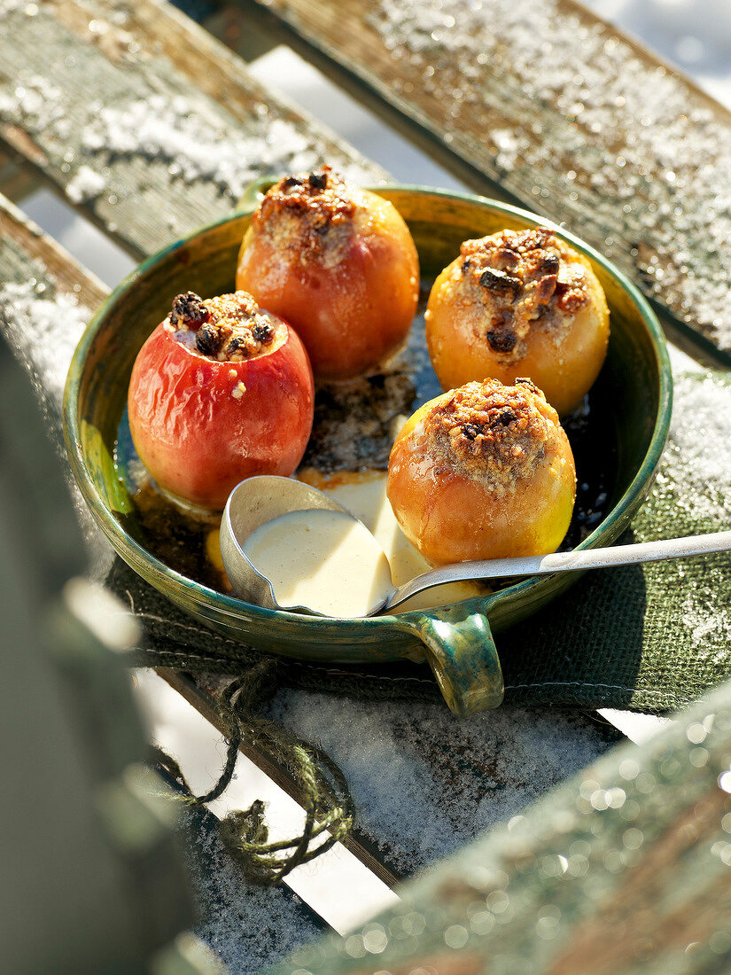 Baked stuffed apples with vanilla sauce in serving dish for winter