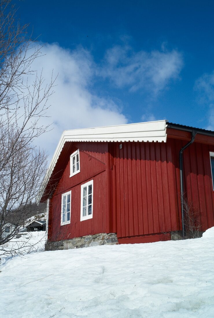 View of red traditional wooden house in Hemsedal ski resort, Norway