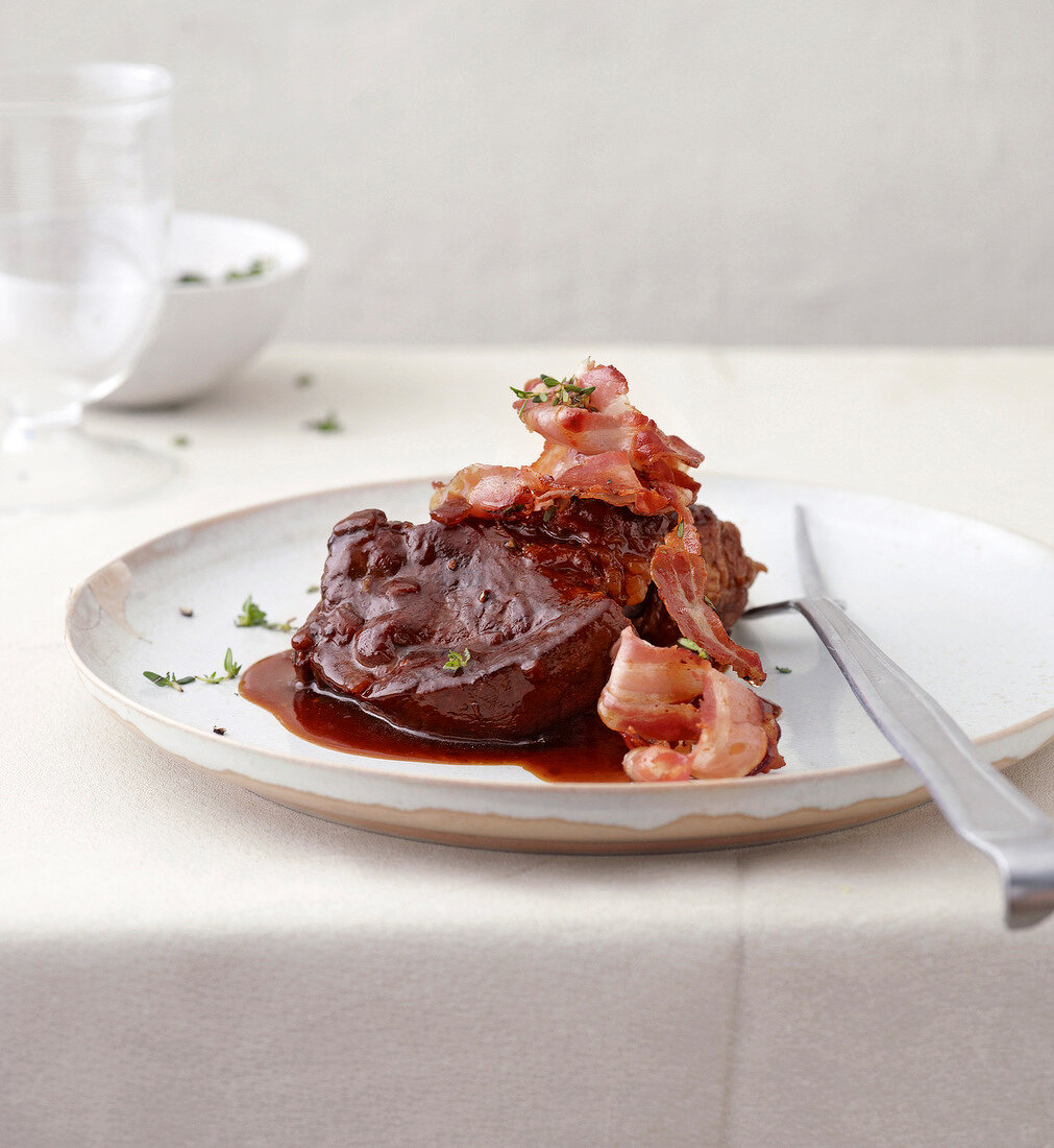 Beef with wine and pancetta on plate