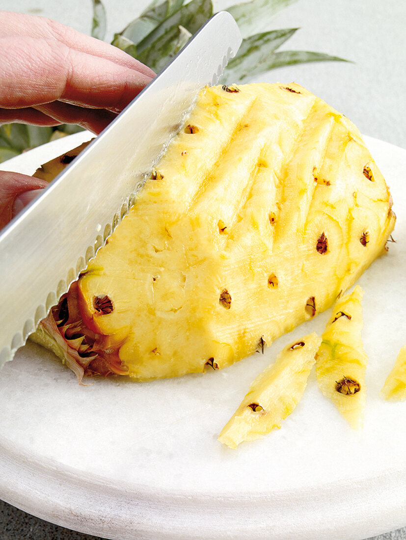 Raclette u. Fondue, mit Messer Augen von Ananas entfernen