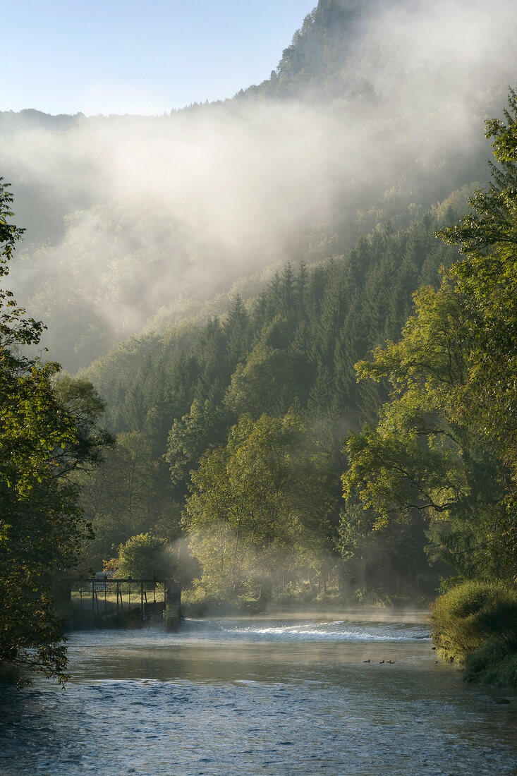 View of Loue river with fog near the village of Lods, Franche-Comte, France