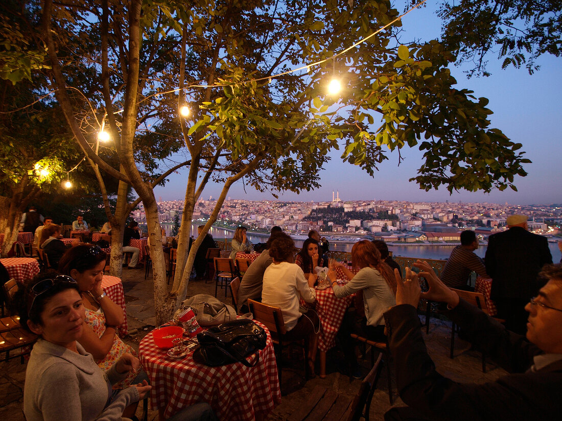 People sitting at restaurant in Bosphorus, overlooking city, Istanbul, Turkey