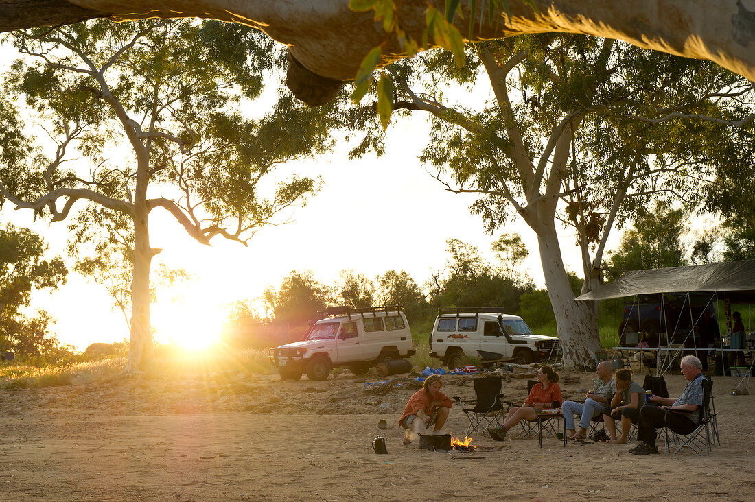 People sitting around camp fire in Ormiston Creek, Alice Springs, Australia
