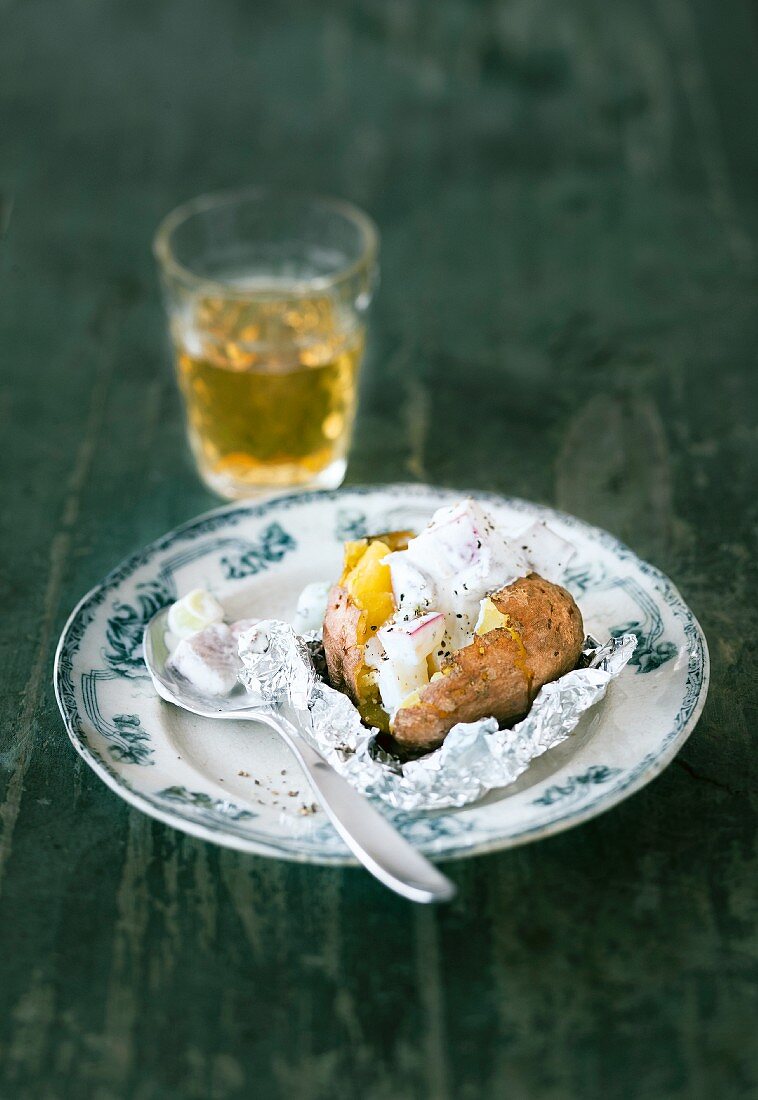 Baked potato with soused herring and sour cream