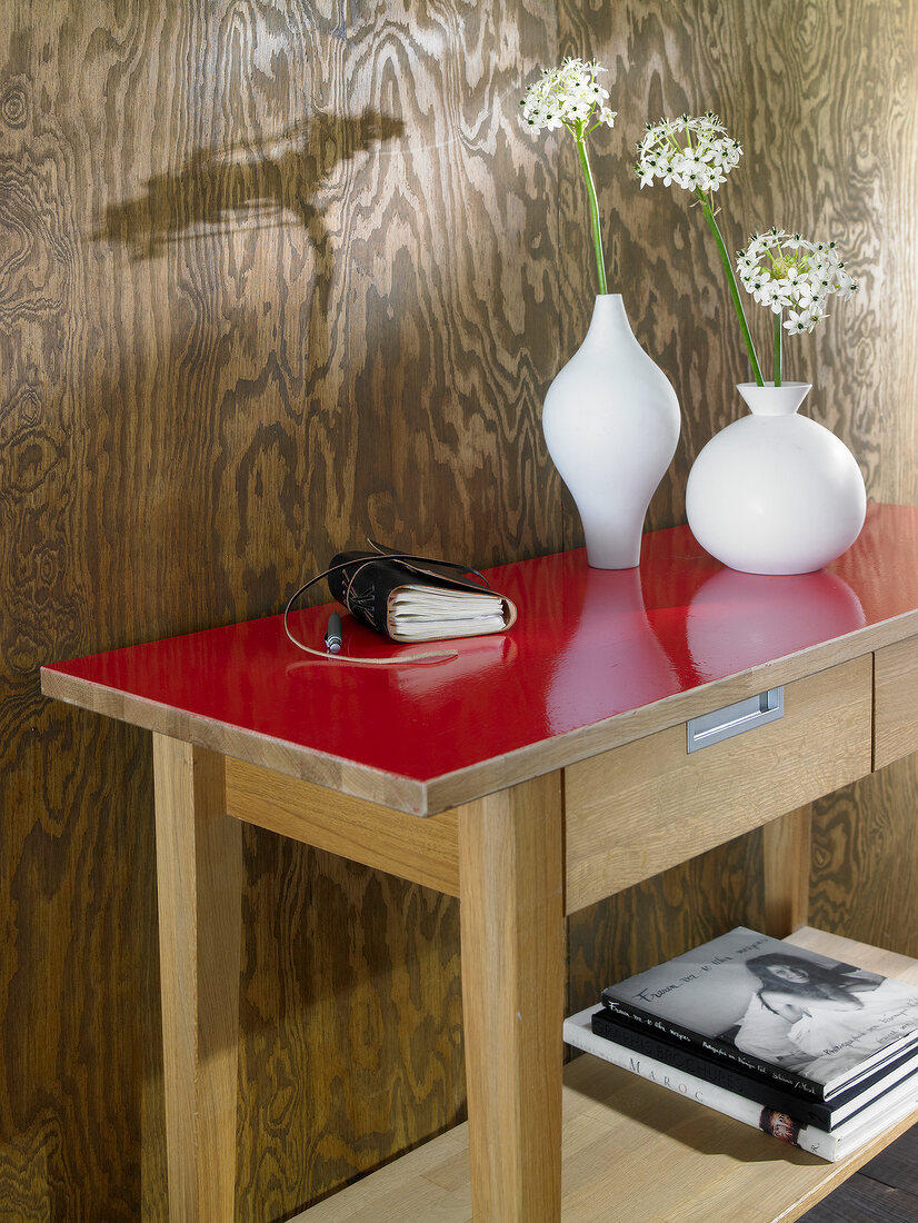 Close-up of wooden sideboard with red lacquer and flower vases