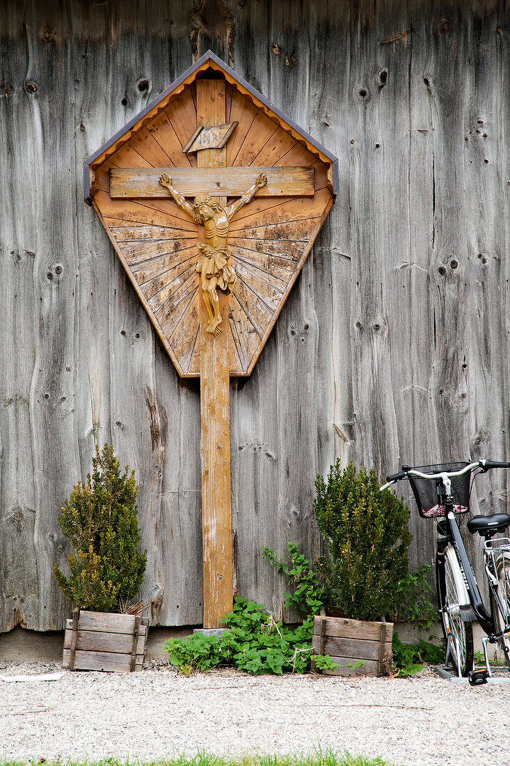Wooden cross of Jesus Christ across wooden wall