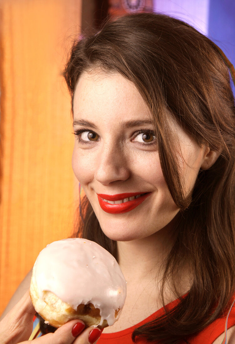 Woman in orange top eating donuts