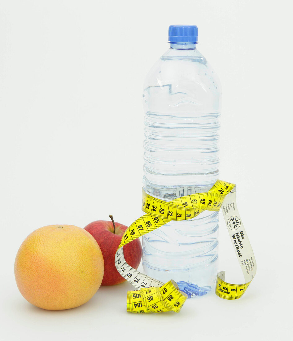 Symbolbild für Diät, Flasche Wasser mit Maßband und Früchte