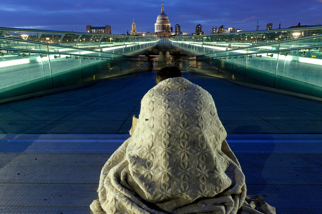 Rear view of man on Millennium Bridge, Tate Modern and St Paul's Cathedral at London, UK