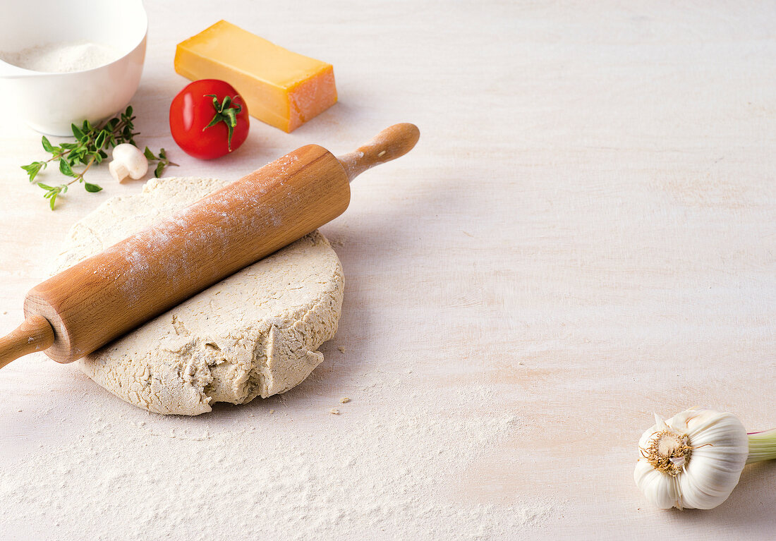 Rolling pin on dumpling dough with other ingredients, copy space
