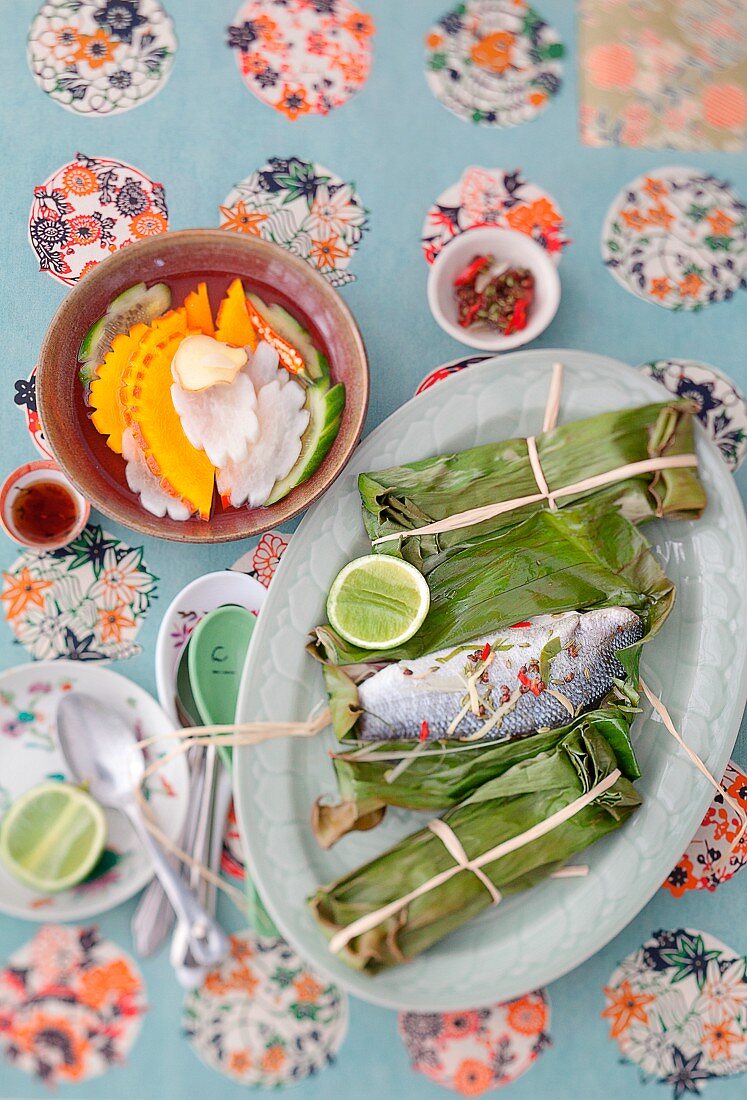 Wolfsbarsch in Bananenblatt gebacken und eingelegtes Gemüse (Vietnam)