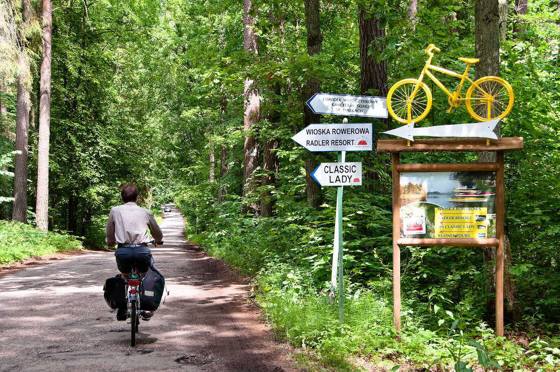 View of cyclist passing through ResortX at Warmia-Masuria near Mikolajki forest, Poland