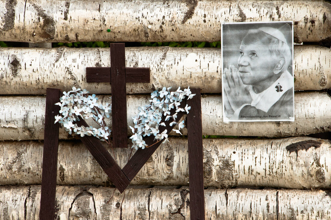 Photo of Pope John Paul II and Crucifix on pile of woods, Mikolajki, Poland