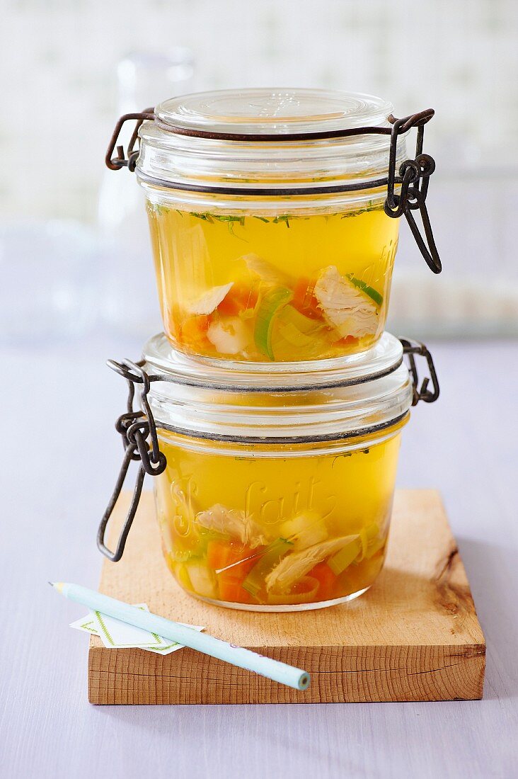 Homemade chicken soup in preserving jars