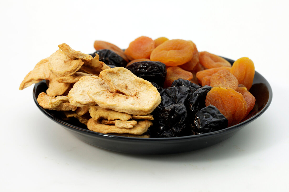 Dried fruits in plate on white background