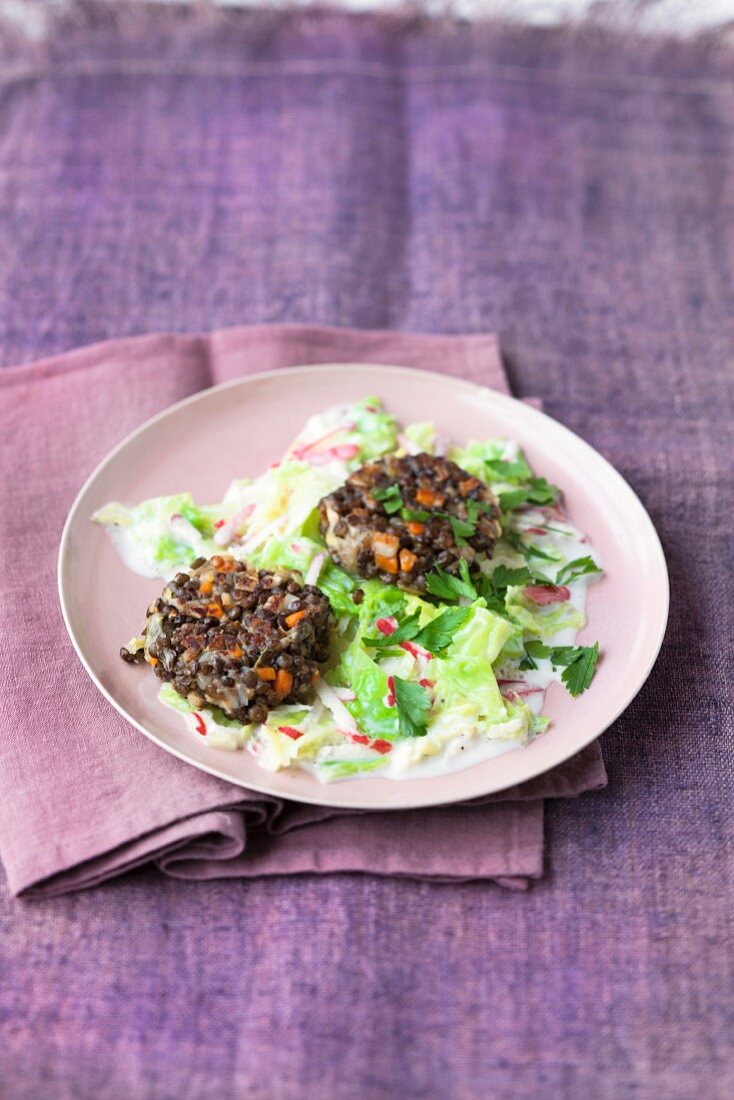 Lentil cakes made with small green lentils on a savoy cabbage medley with apple