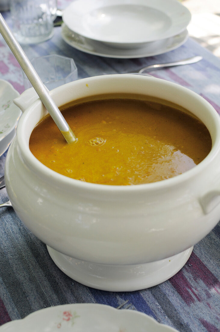 Suppe in Suppenterrine auf Tisch, Kürbiscremesuppe, Kürbissuppe
