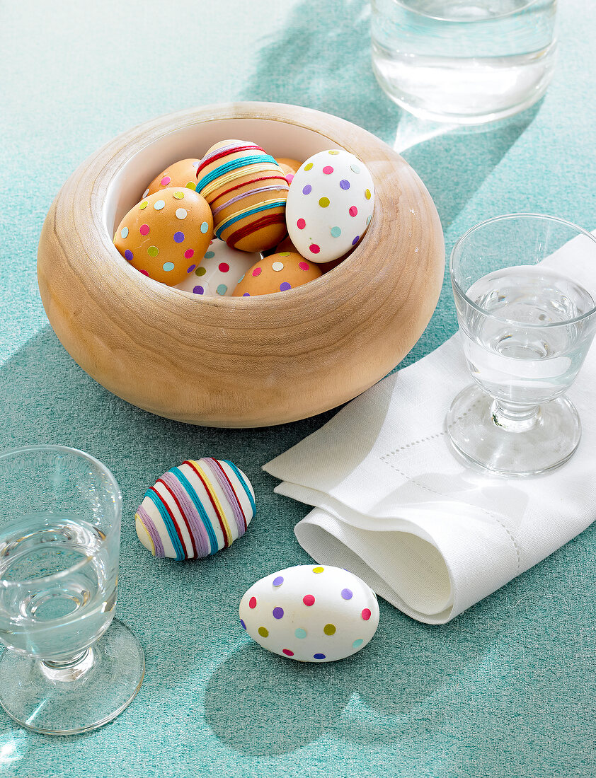Easter eggs in bowl decorated with confetti and cotton threads