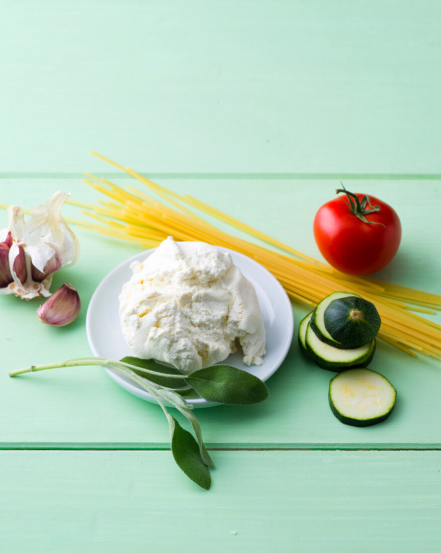 Various ingredients for making pasta on green background